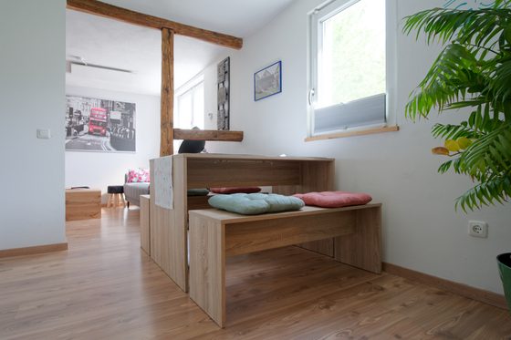 Essbereich mit Sitzbänken und freiliegendem Fachwerkbalken