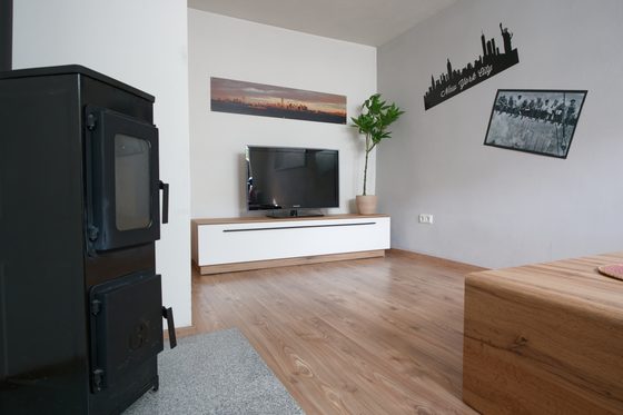 Wohnbereich mit Kaminofen und Fernseher
